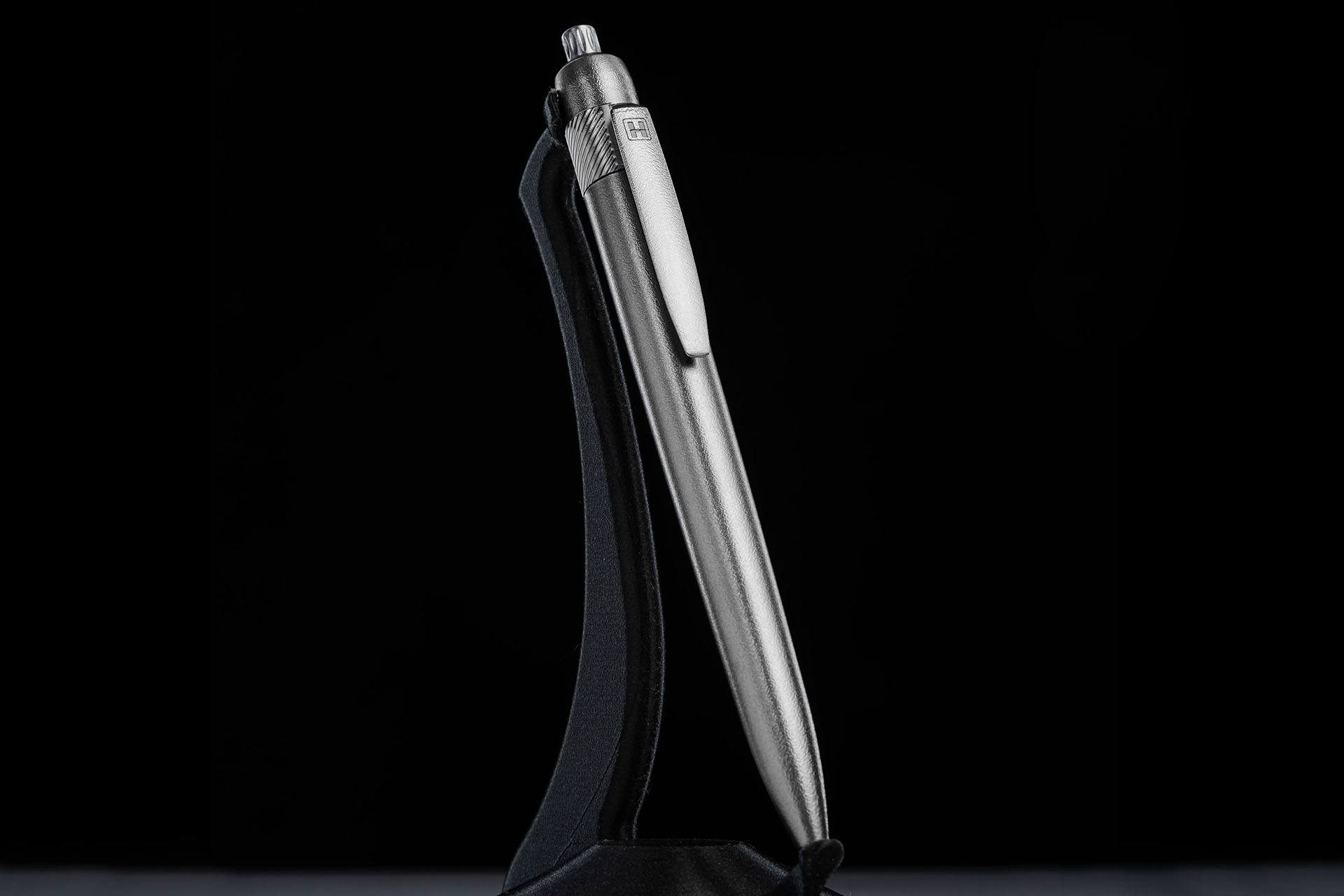Herman Epika titanium pen standing on display stand, full-length view