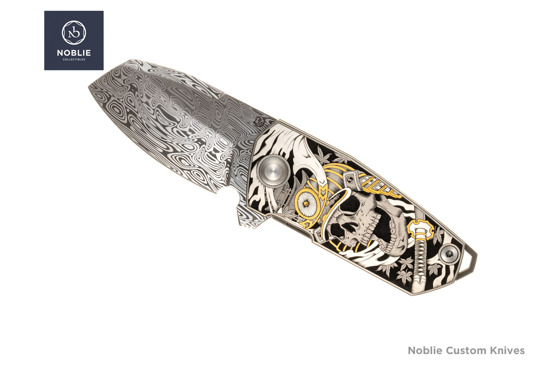 Skladací nôž Samurai Skull Damasteel s ručne gravírovanou titánovou rukoväťou a zlatými detailmi.